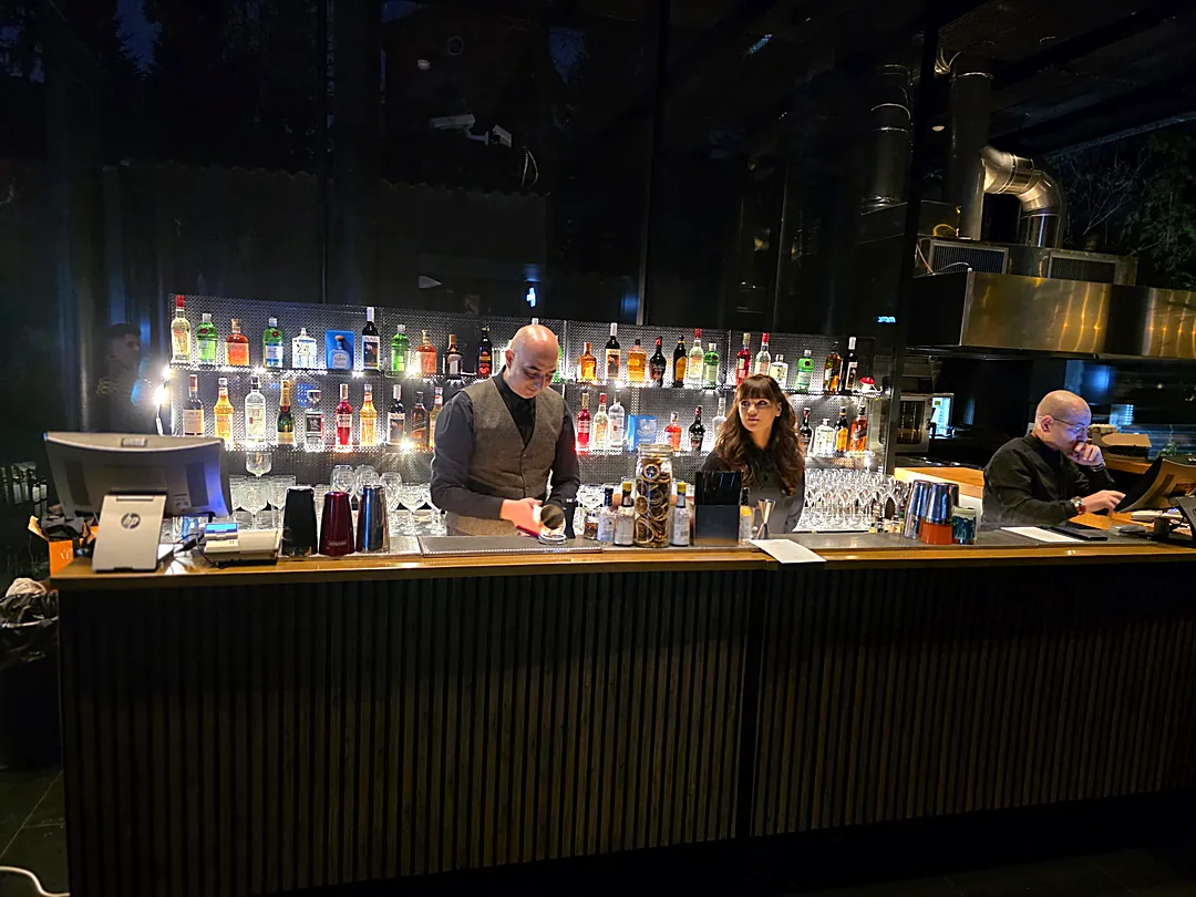 Bar mobil cu backbar iluminat și barmani pregătind paharele, la un eveniment de seară Cofftails Events