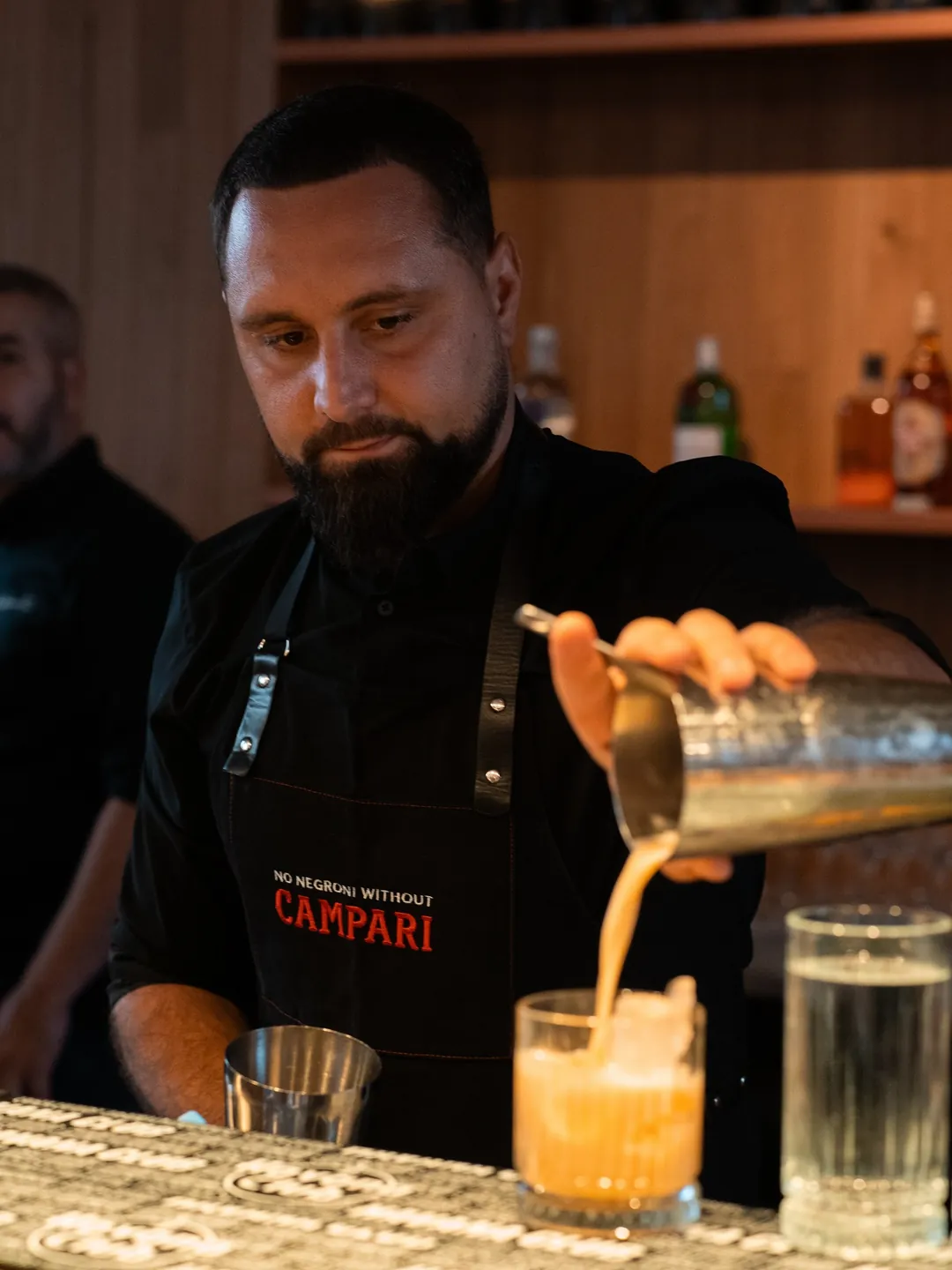 Barman Cofftails Events turnând un cocktail proaspăt preparat