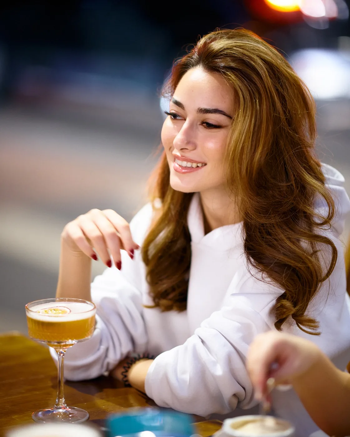 Clientă cu un cocktail într-o seară la Cofftails
