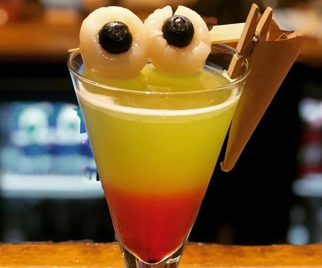 Cocktail tropical în degrade, garnisit cu litchi, la Cofftails