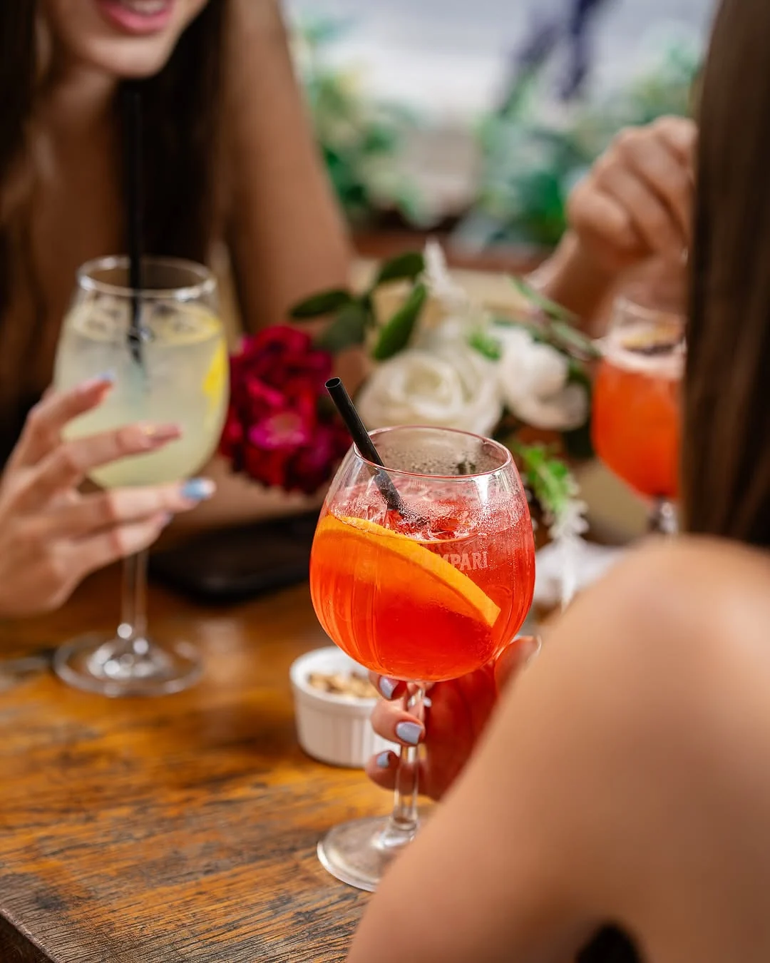 Prieteni bucurându-se de cocktailuri craft pe terasa din București