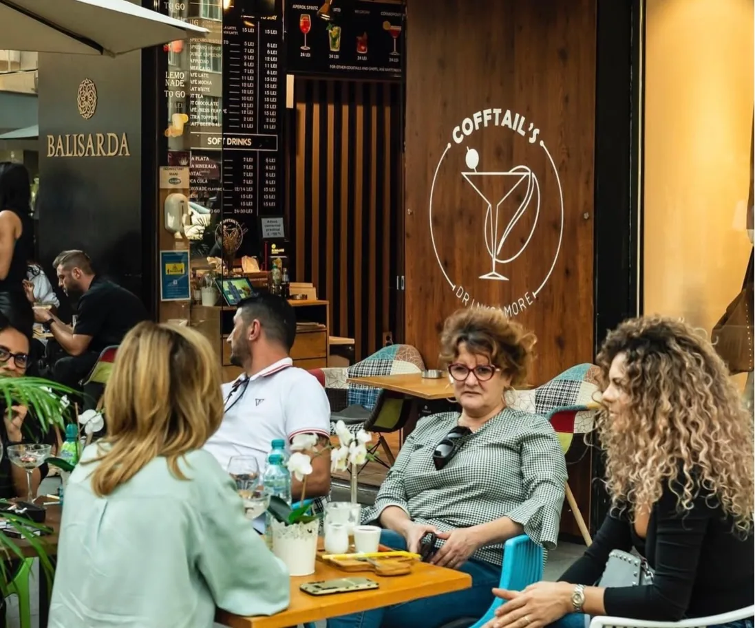 Oaspeți la mesele de pe terasa Cofftails de pe Calea Victoriei